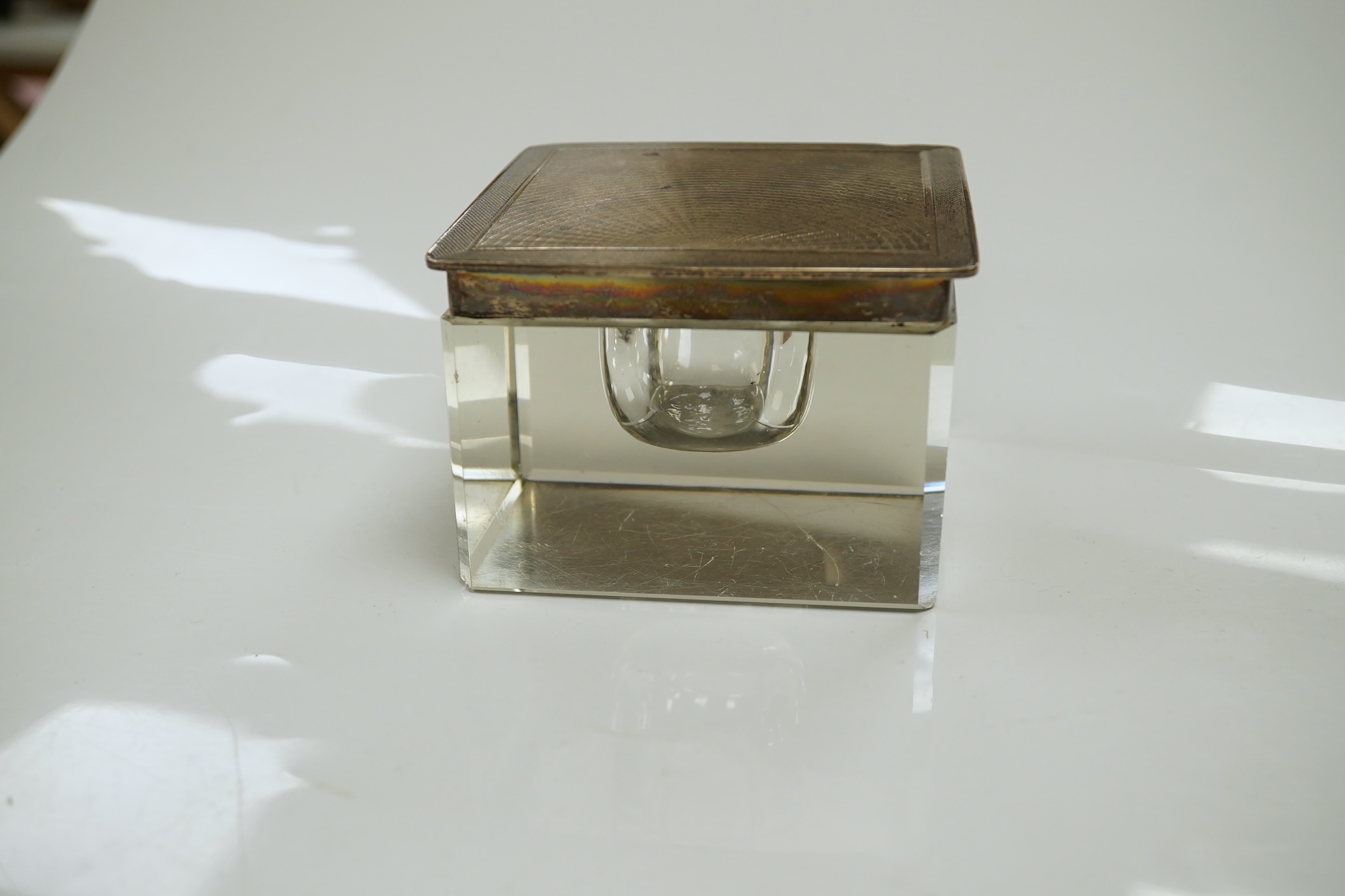 A George V silver lidded glass square inkwell, by Henry Matthews, Birmingham, 1929, width 95mm. Condition - poor to fair